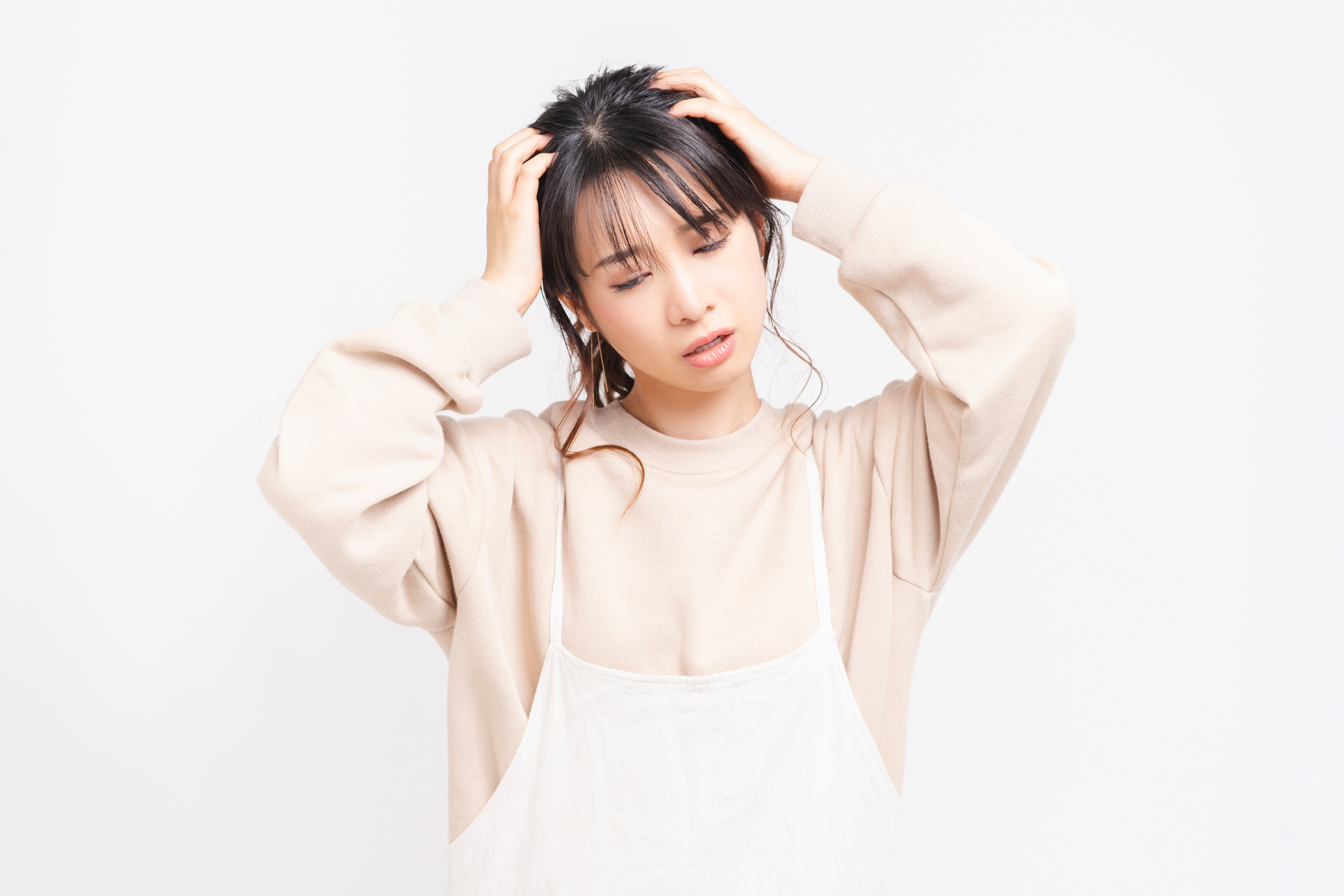 頭を抱えて悩む女性